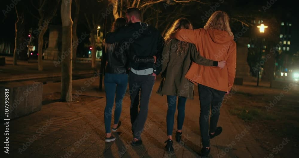 Young happy couples embracing while taking a night walk outside Young happy couples embracing while taking a night walk outside