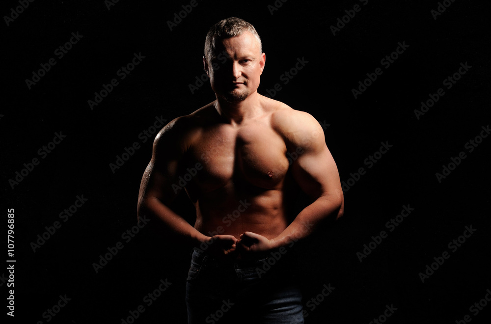 Obraz premium Muscular male posing on black background