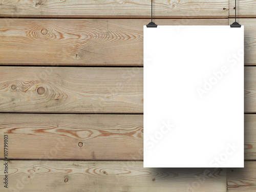 Close-up of one blank frame hanged by clips against brown horizontal wooden boards background