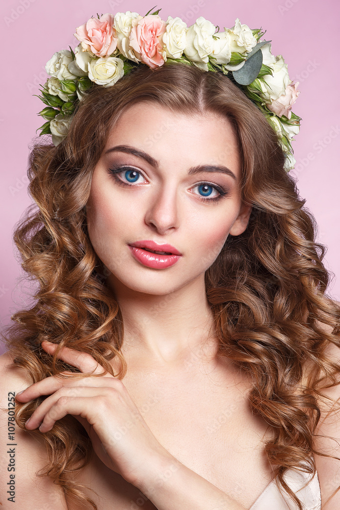 Naklejka premium Beautiful young girl with a floral ornament in her hair.Beautiful Woman Touching her Face. Youth and Skin Care Concept.Nymph. Portrait of Genuine Gorgeous Woman in Wreath of Flowers