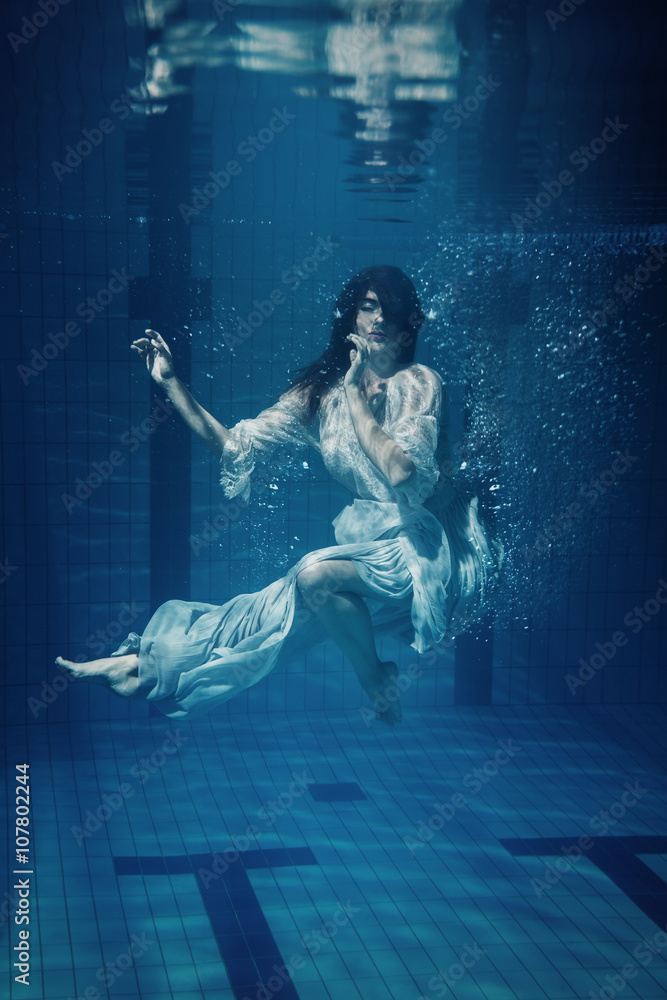 Woman in beautiful dress underwater