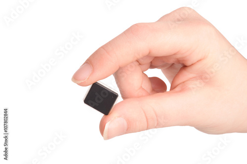 Close-up view of young girl hand holding transistor based microchip and gesturing with it, taken on white background. Nanotechnology concept