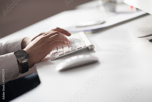 hands typing on desktop computer