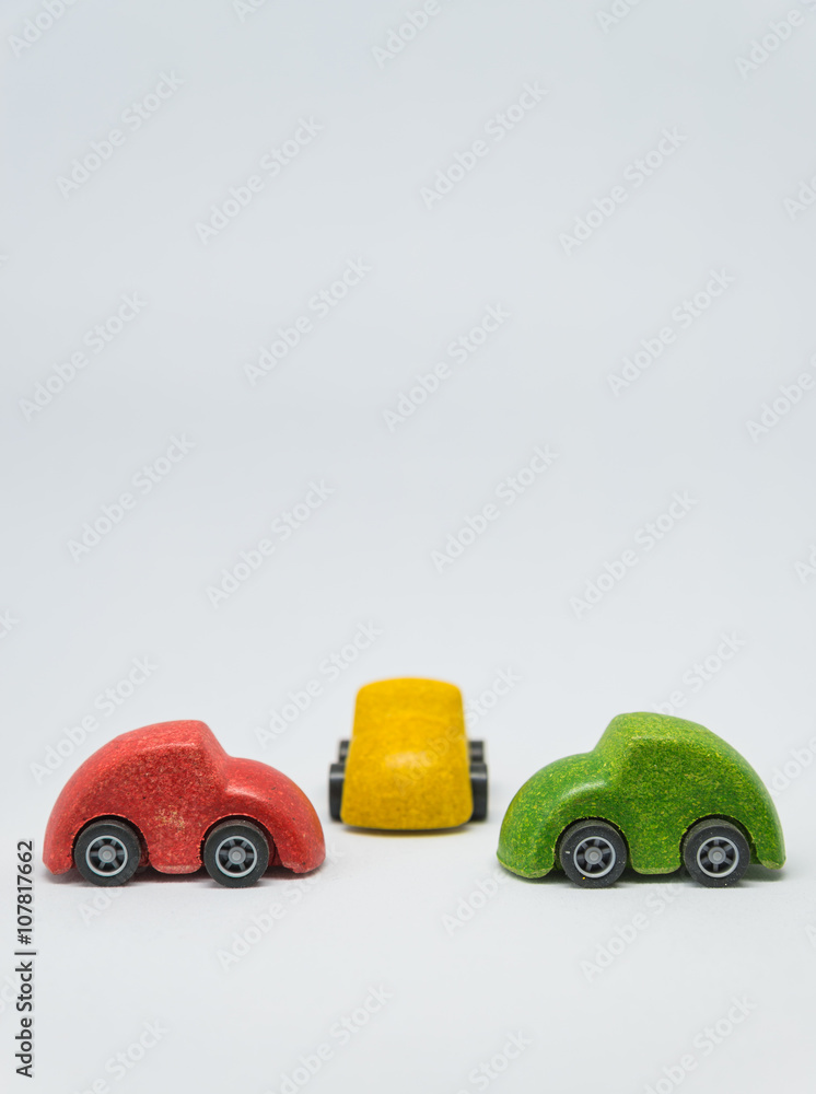 Three colorful toy car parked intersection with white background and selective focus Three colorful toy car parked intersection with white background and selective focus