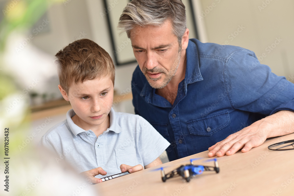 Dad and son playing with toy drone Dad and son playing with toy drone
