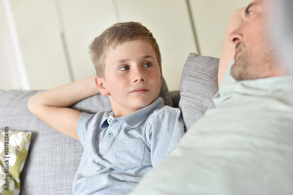 Daddy with son relaxing on sofa
