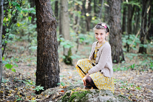 Portrait of cute child girl i in autumn park photo