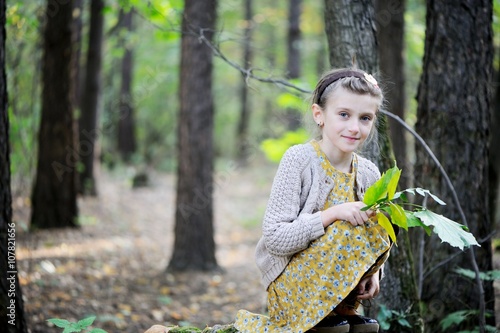 Portrait of cute child girl i in autumn park photo