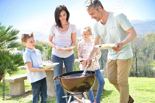 Family having barbecue lunch in garden