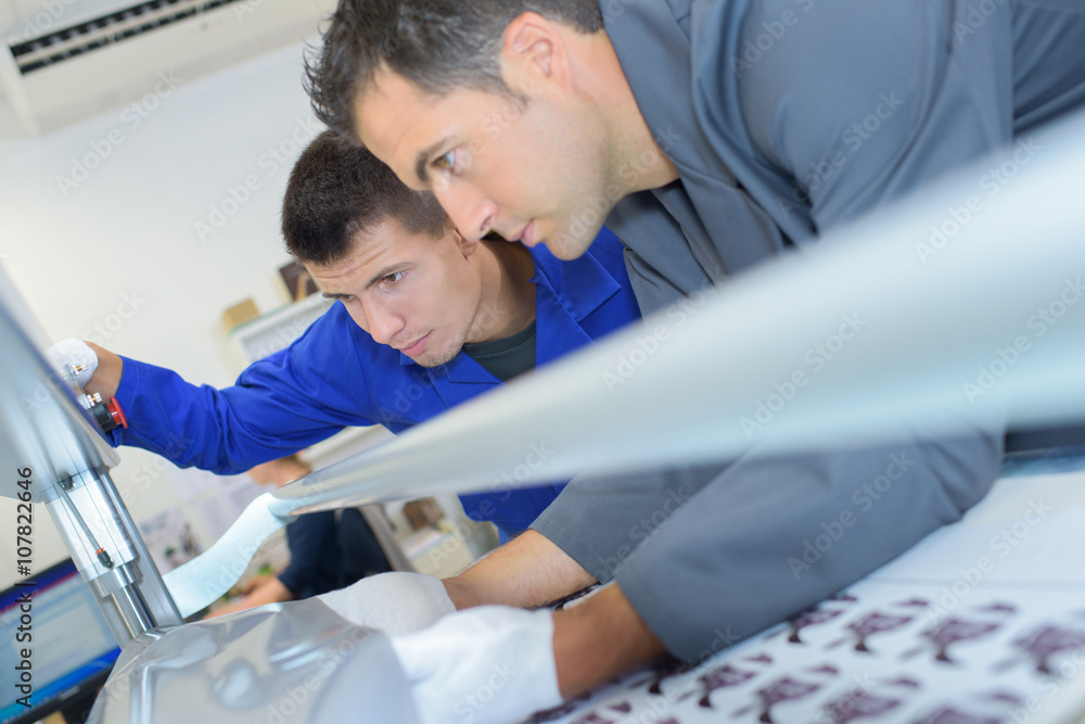 Obraz premium Two men setting up professional printing machine