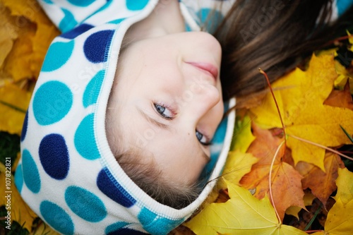 Smiling girl close-up view in golden leaves