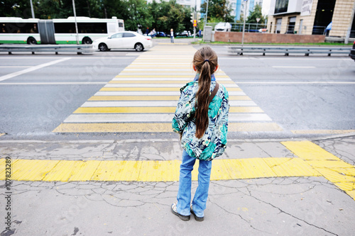 Kid girl standing near the pedestrian crossing photo