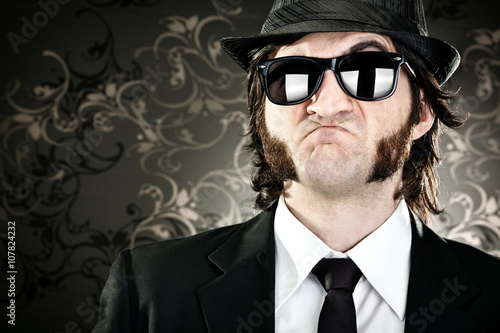 Fotografia elegant boss man with sideburns and sunglasses on black backround
