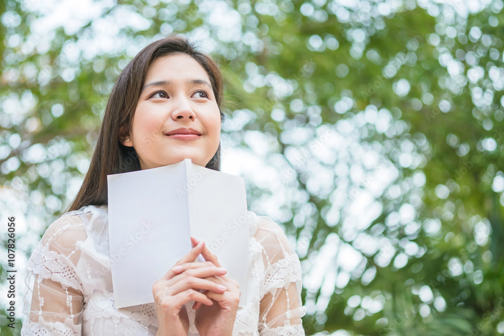Woman with a book in happy emotion in the park view background Woman with a book in happy emotion in the park view background