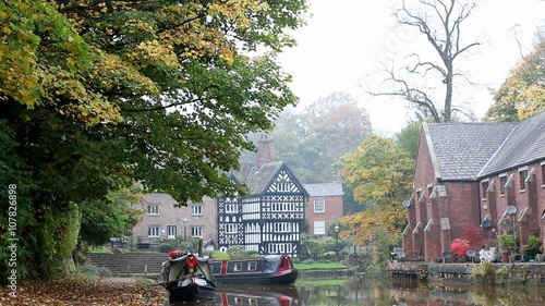Narrow boat is making a turn on picturesque Bridgewater Canal in Worsley, England in autumn photo