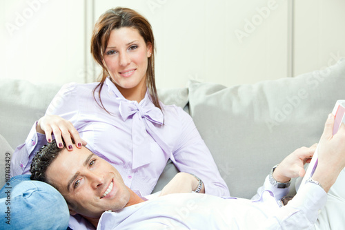 young happy couple relax on couch at home