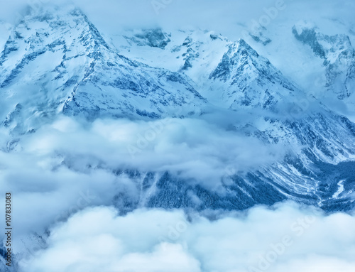 majestic winter landscape of Dombaj mountains covered peaks with clouds