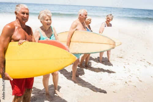 Senior friends holding surfboard