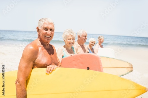 Senior friends holding surfboard