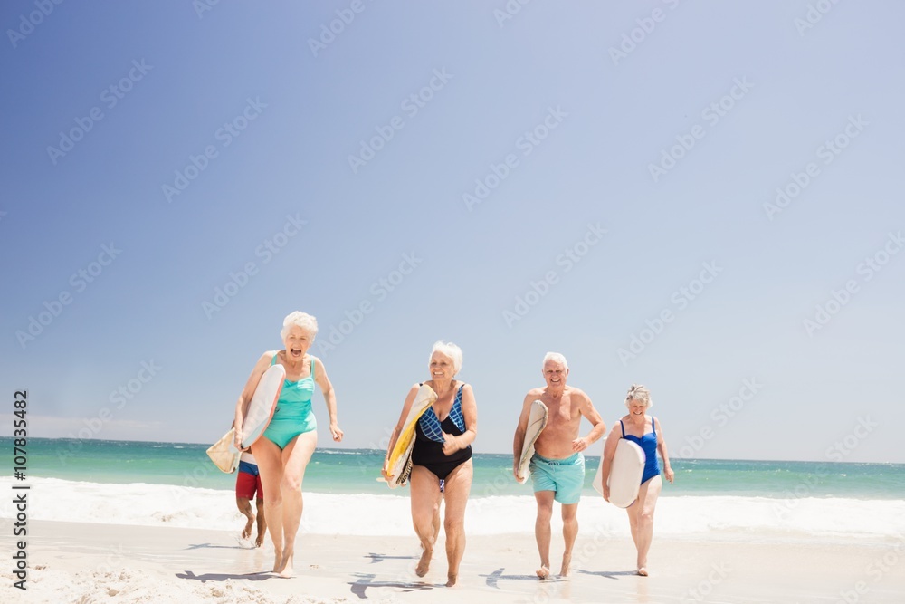 Senior friends holding surfboard