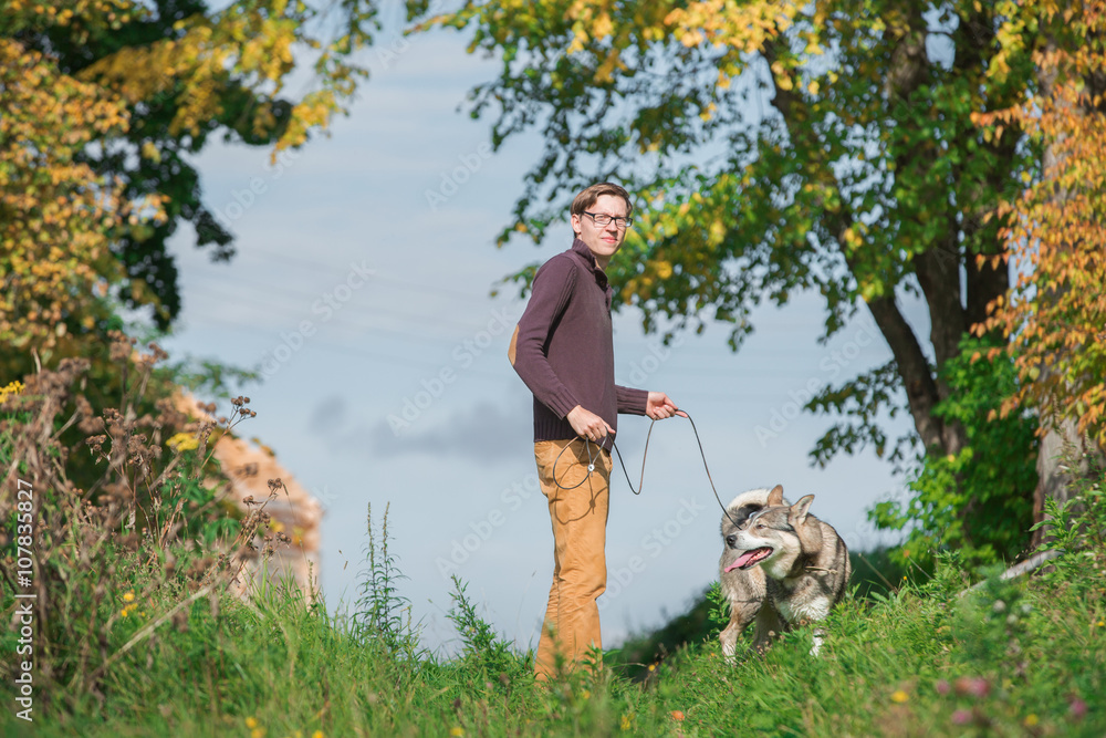 Man walking with a hunting dog - the West Siberian husky.