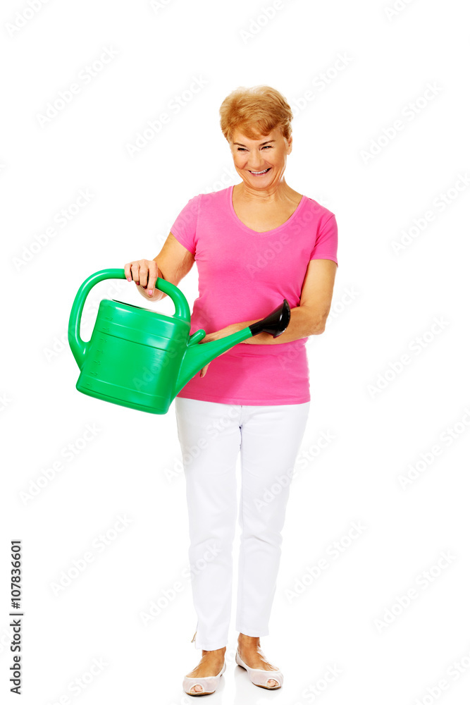 Smiling senior woman with green watering can Smiling senior woman with green watering can