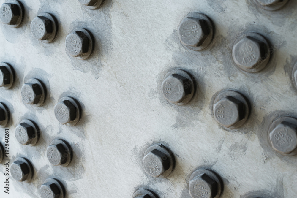 Gray metal surface with hexagonal bolt heads Gray metal surface with hexagonal bolt heads