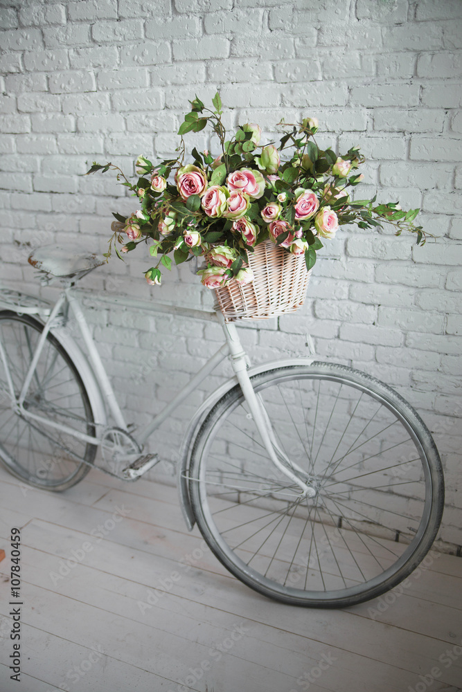 Old bicycle and flowers close to the white brick wall