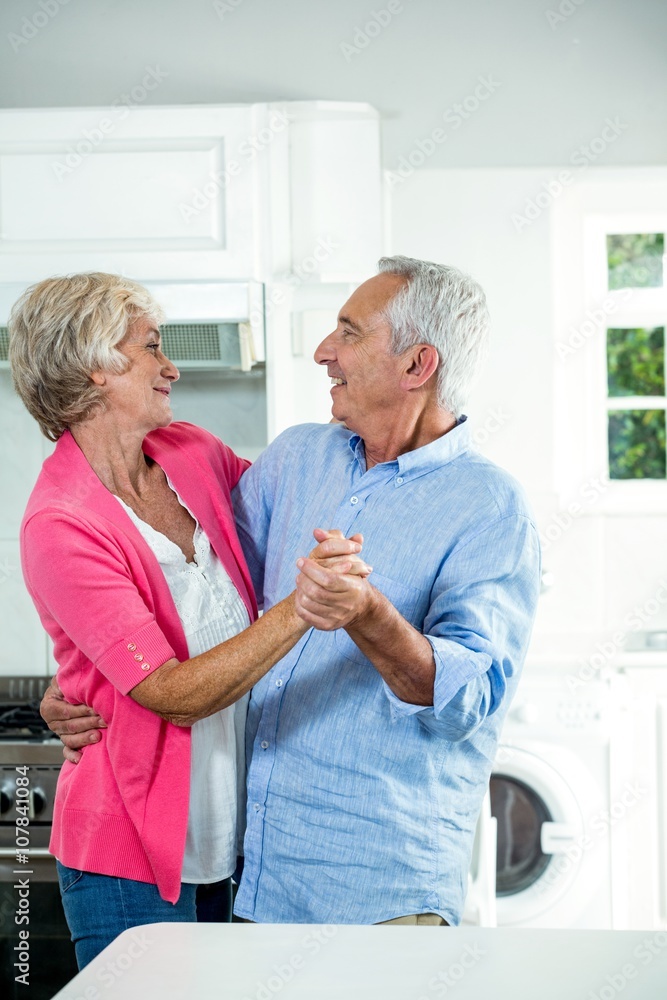Happy senior couple dancing while standing Happy senior couple dancing while standing