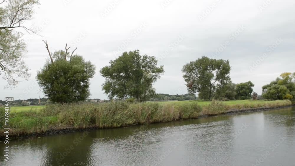 driving with boat along havel river. typical landscape with meadows and willow tries. Havelland region. (Germany) driving with boat along havel river. typical landscape with meadows and willow tries. Havelland region. (Germany)