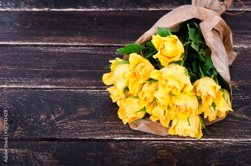 Yellow roses bouquet on the wooden background