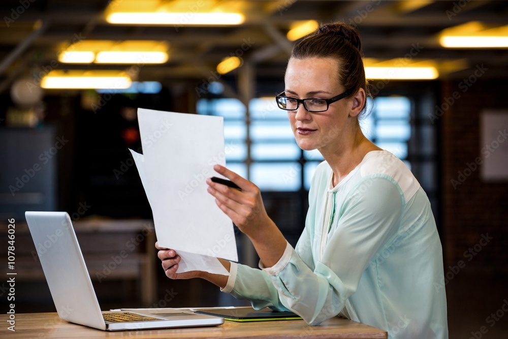 Fototapeta premium Woman reading a document in office