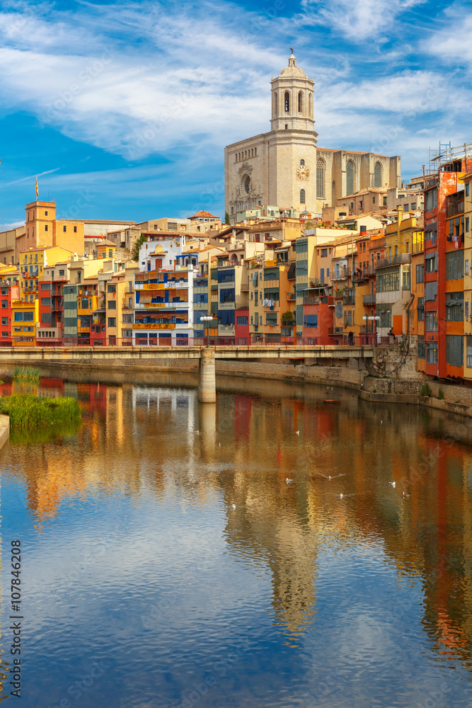 Saint Mary Cathedral, colorful yellow and orange houses and famous white house Casa Maso reflected in water river Onyar, in Girona, Catalonia, Spain.  