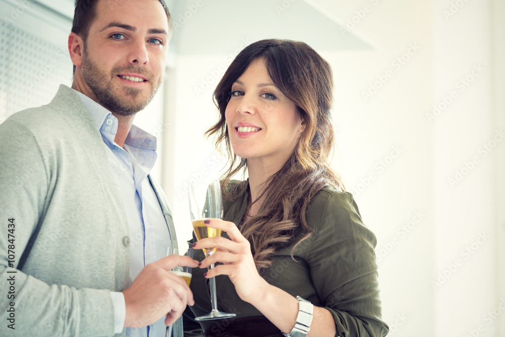 young casual couple cheers with champagne in the kitchen young casual couple cheers with champagne in the kitchen