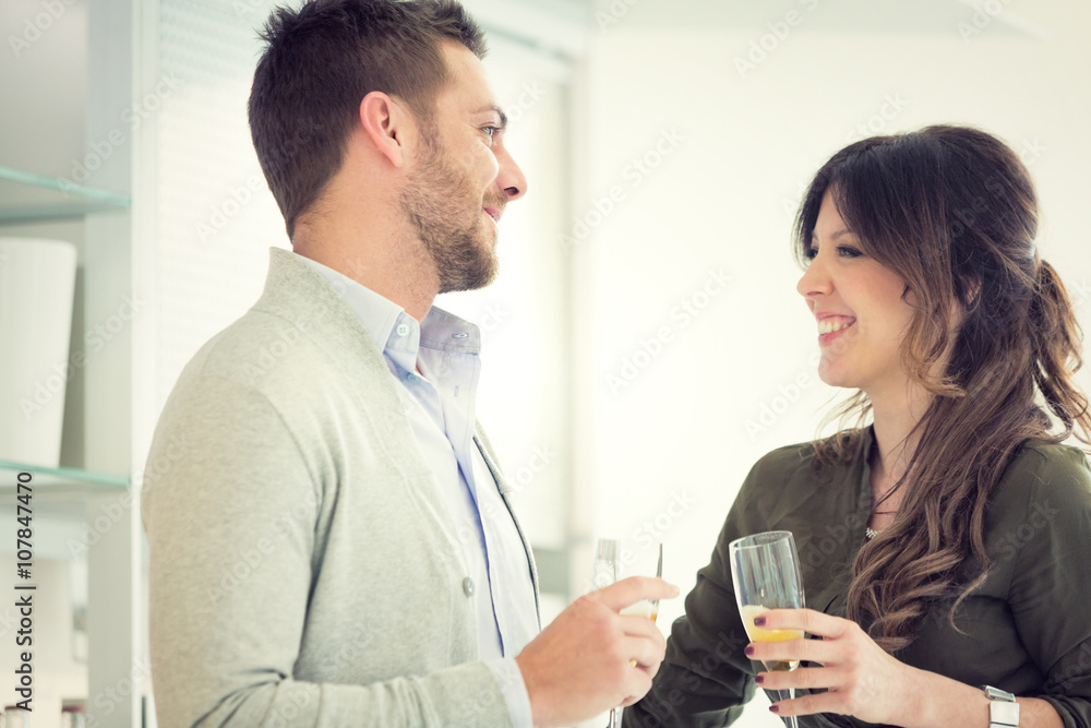 young casual couple cheers with champagne in the kitchen young casual couple cheers with champagne in the kitchen