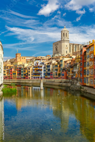 Saint Mary Cathedral, colorful yellow and orange houses and famous white house Casa Maso reflected in water river Onyar, in Girona, Catalonia, Spain.   photo