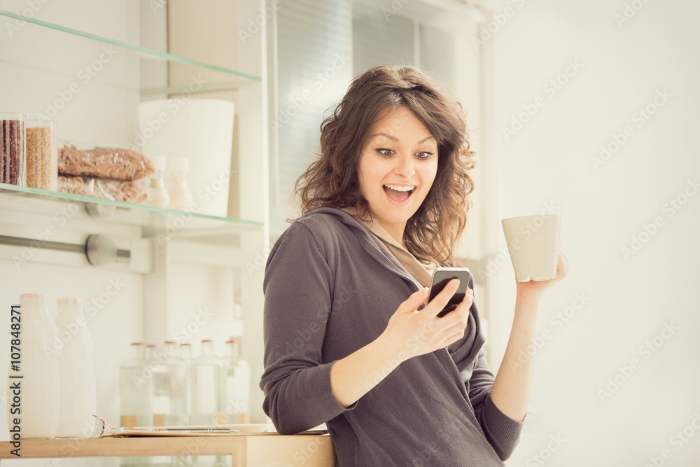 young smiling woman with cup of tea in the kitchen young smiling woman with cup of tea in the kitchen