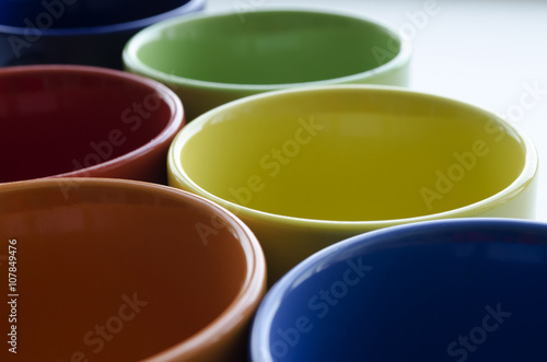 brightly colored ceramic cups on a light background 