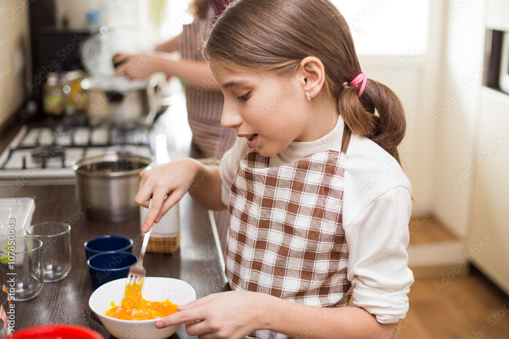 Teenage girl mixing eggs in bowl with whisk Teenage girl mixing eggs in bowl with whisk
