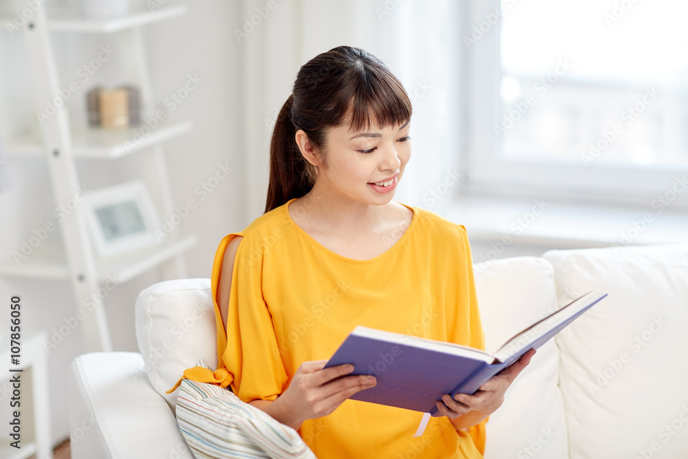 smiling young asian woman reading book at home smiling young asian woman reading book at home