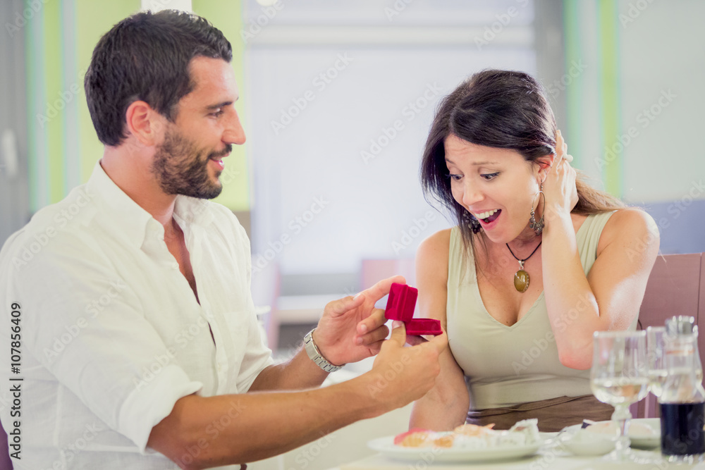 young romantic man proposal to girlfriend at restaurant