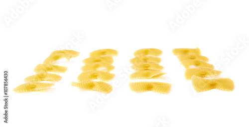 Single pieces of dry farfalle pasta over isolated white background
