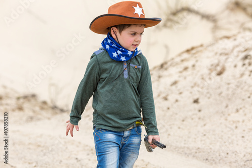boy in a sheriff hat with a gun