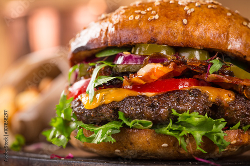 Tasty burgers on wooden table.