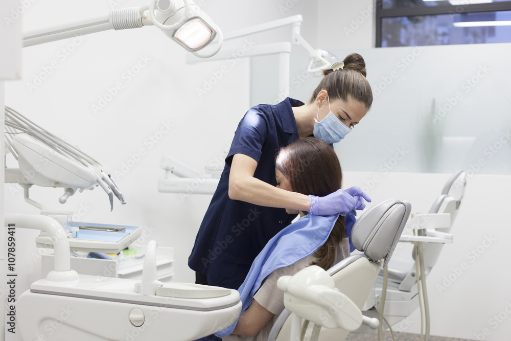 Obraz premium Beautiful woman patient having dental treatment at dentist's office. Woman visiting her dentist