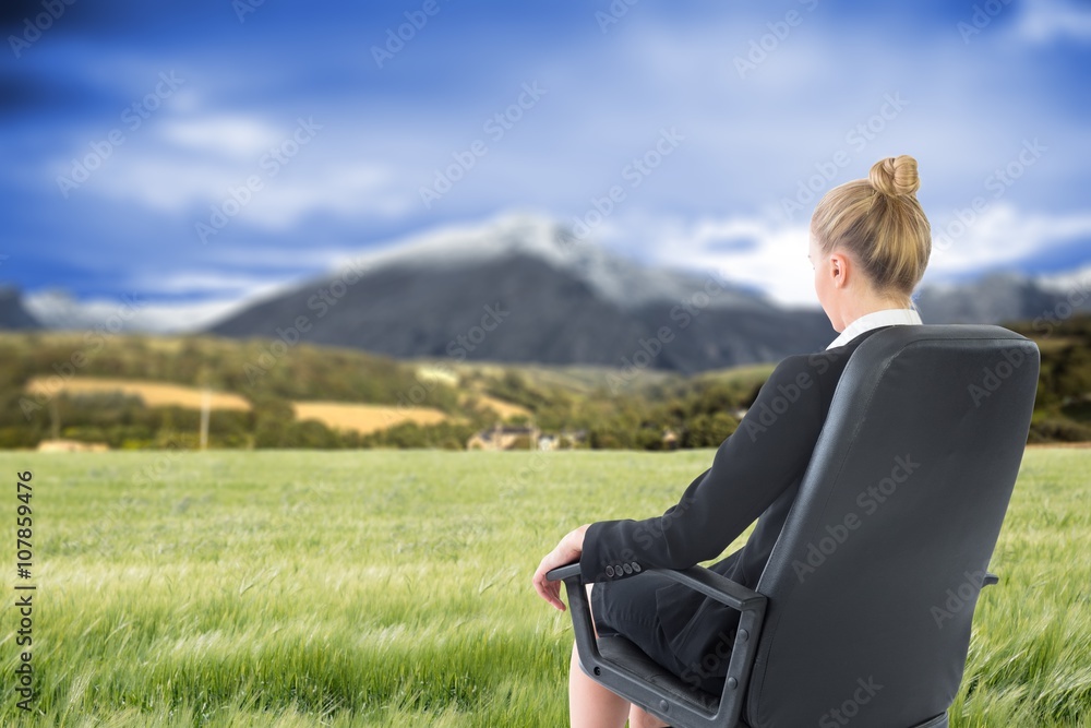 Composite image of businesswoman sitting on swivel chair in blac Composite image of businesswoman sitting on swivel chair in blac