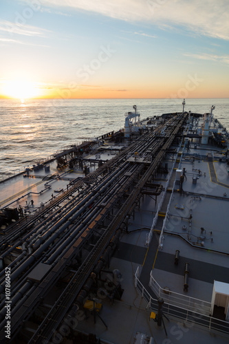 Vertical image oil tanker in ocean when sunset.