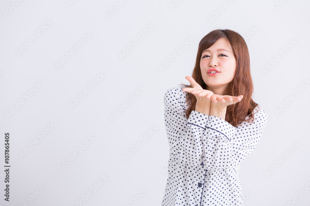 投げキッスをするパジャマの女性 投げキッスをするパジャマの女性