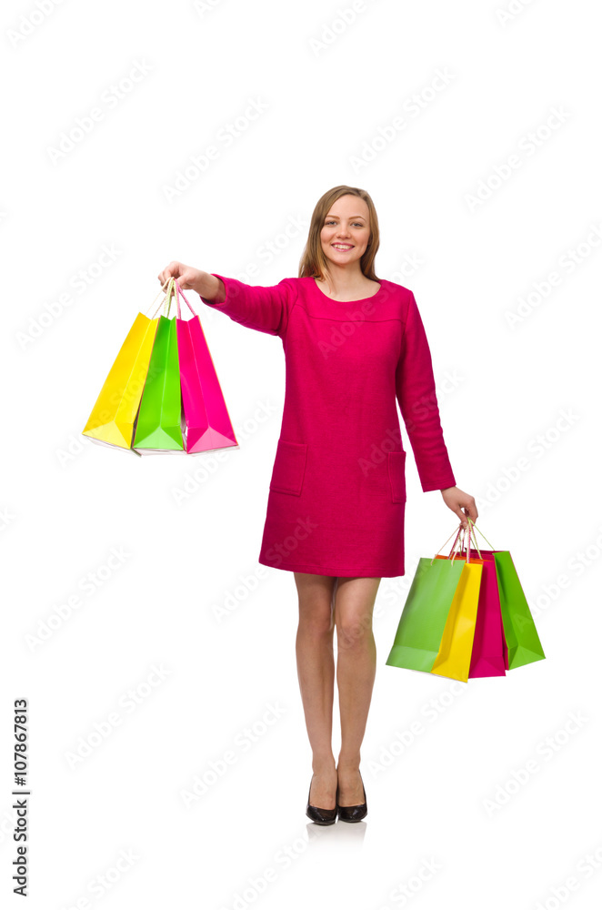 Shopper girl in pink dress holding plastic bags isolated on whit