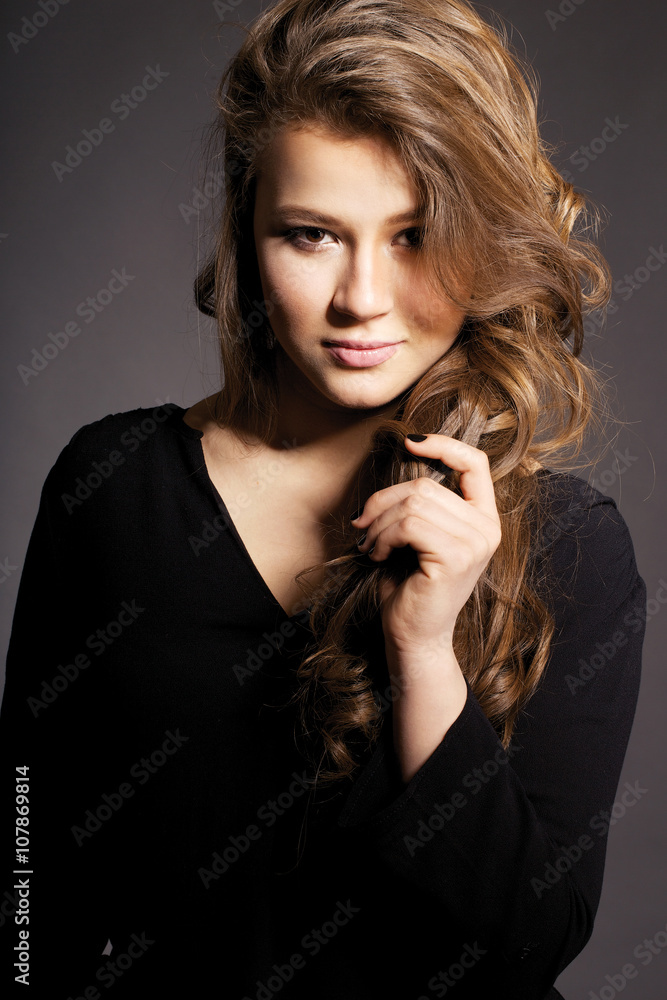 young beautiful girl with wavy hair on a black background young beautiful girl with wavy hair on a black background
